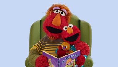 Elmo and his father reading a storybook
