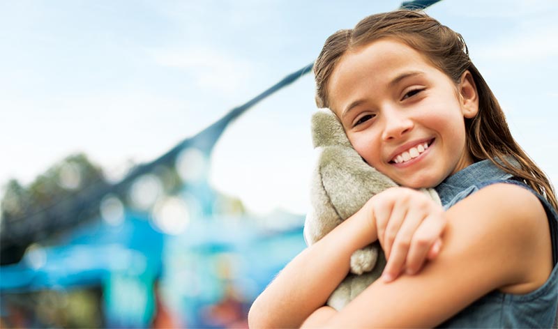 Girl hugging dolphin plush