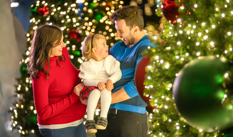 Family next to Christmas trees