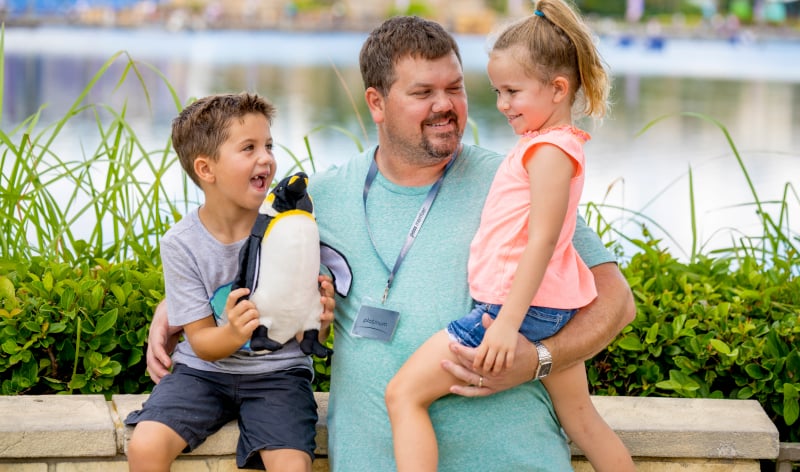 Man with two children and a plush penguin