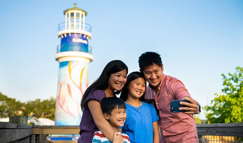 Family selfie at the SeaWorld Orlando entrance lighthouse