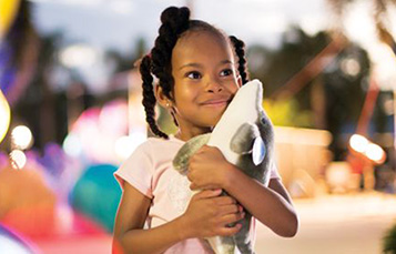 Girl Hugging Dolphin Toy