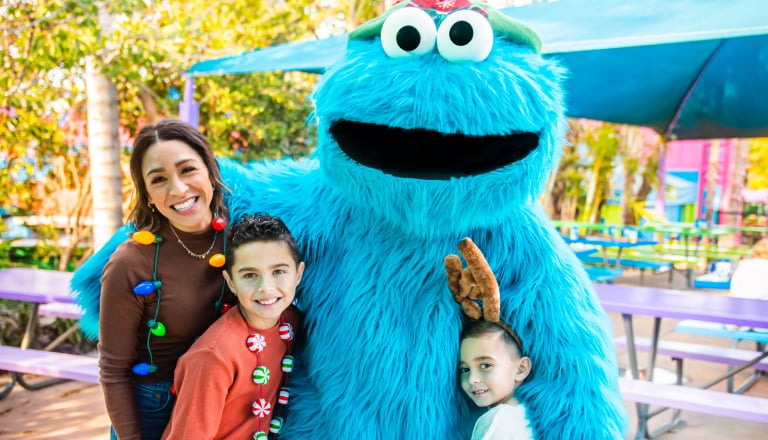 Cookie Monster with a family enjoying Christmas Celebration at SeaWorld San Antonio.