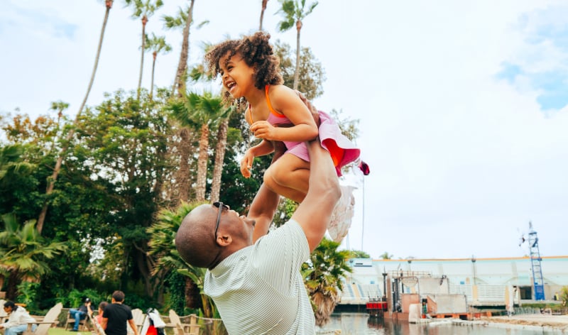 Man holding a child above his head