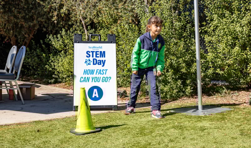 Child next to STEM Day sign