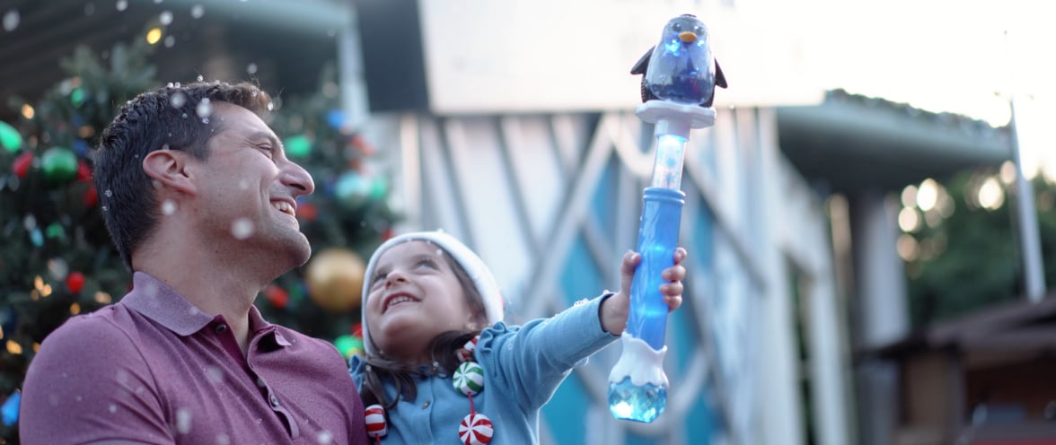 Man holding a child while snow falls