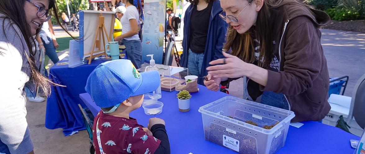 Living Coast activity booth with volunteer and child