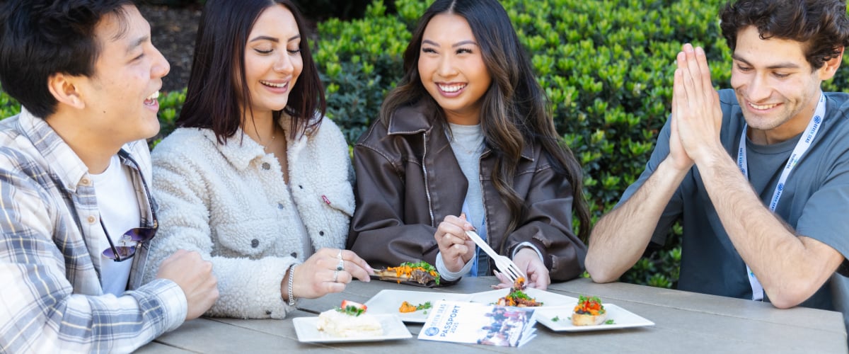 Four adults eating food at a table