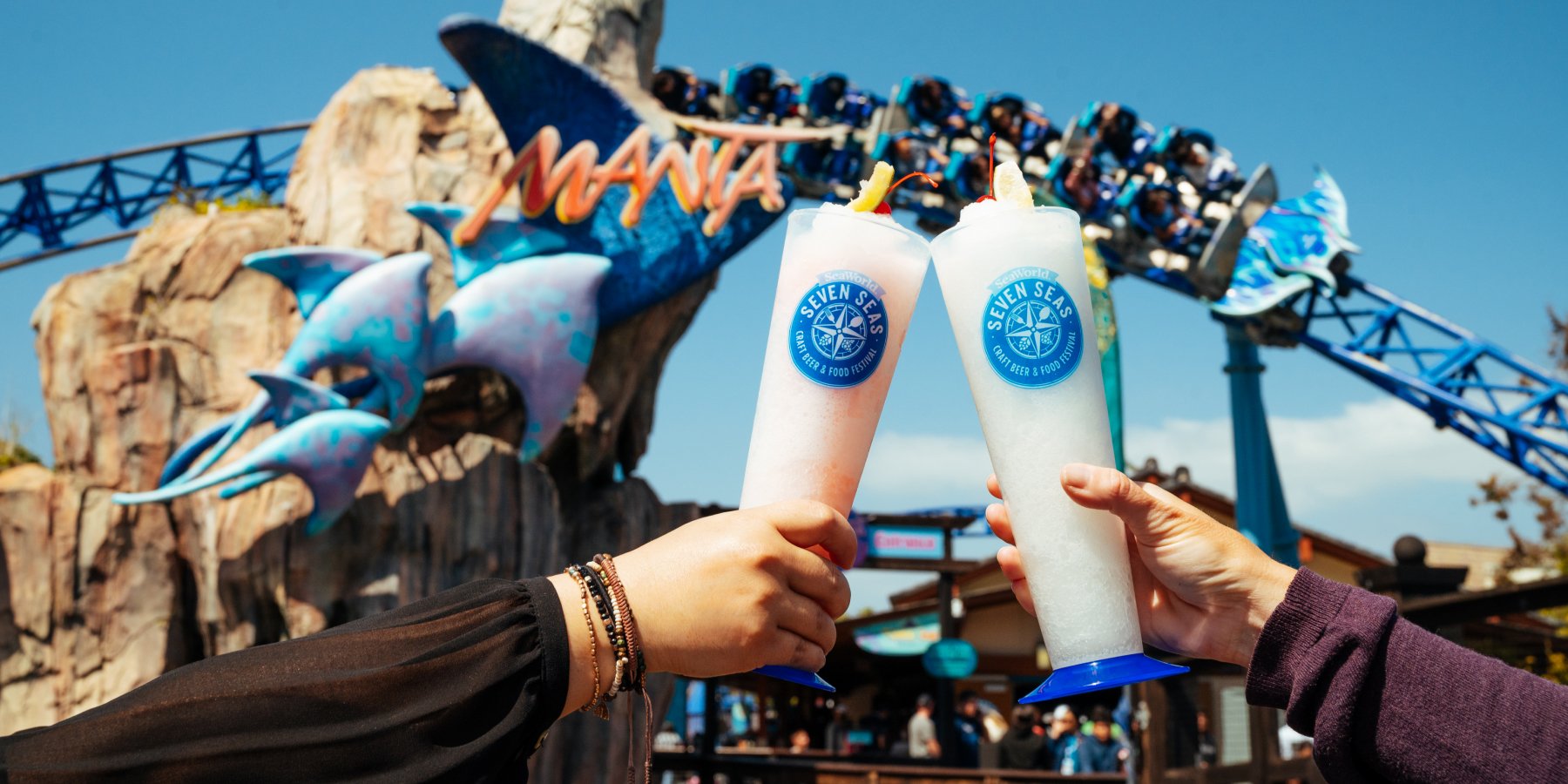 Two frozen drinks in front of Manta roller coaster
