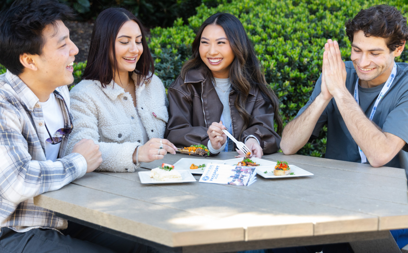 Four adults eating food at a table
