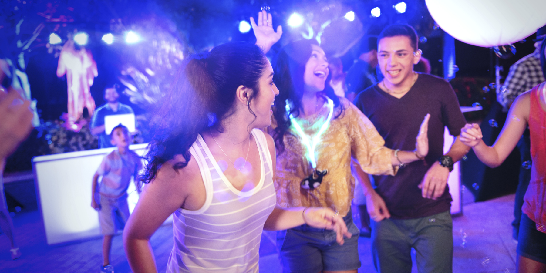 Group of people dancing in black light