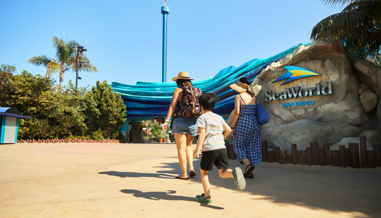 Family walking in front of SeaWorld San Diego sign