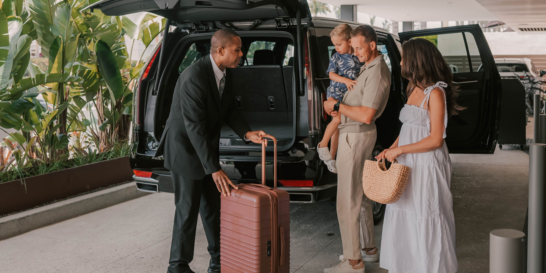 Family waiting for their luggage to be loaded into a van