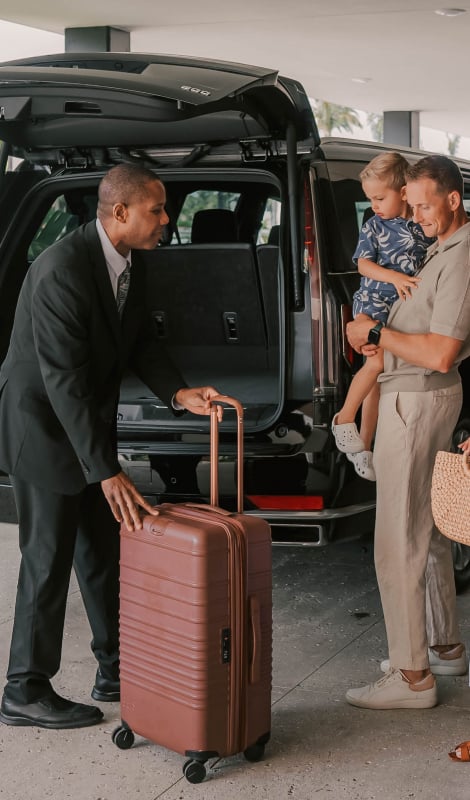 Family waiting for their luggage to be loaded into a van