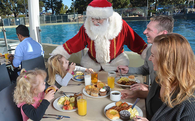 Family eating breakfast and meeting Santa at SeaWorld San Diego Dine with Orcas & Santa experience 