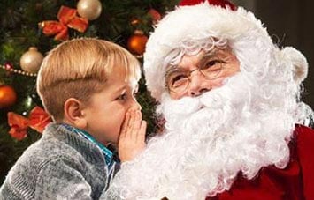Child whispering to Santa